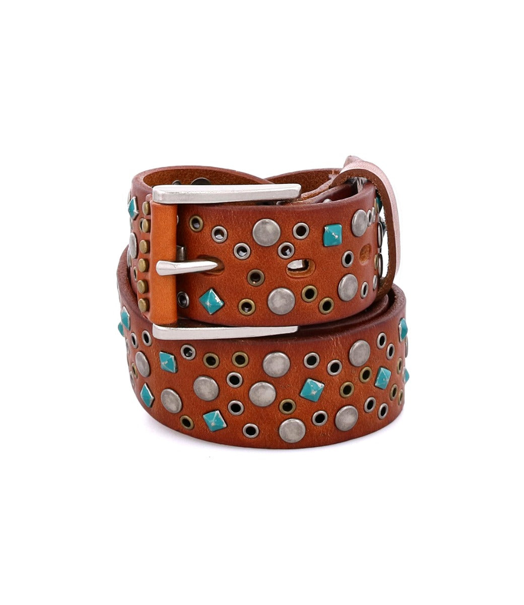 The Bed|Stü Tammin brown leather belt, featuring round silver studs and turquoise square accents with a silver buckle, is rolled up on a white background.