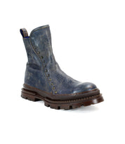 Introducing the Bed|Stü Tanto: a single, rugged blue leather ankle boot featuring a durable leather upper, thick brown lug outsole, and small metal studs along the side, photographed against a white background.