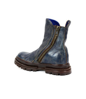The Bed|Stü Tanto boot is shown at an angle against a white background, featuring a streamlined blue leather upper, side zipper, and rugged brown lug outsole.