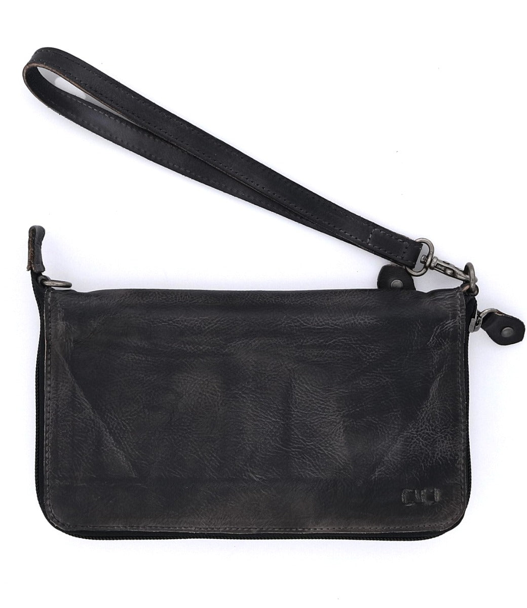 The Bed|Stü Templeton II, a black leather wristlet clutch with a zipper closure and detachable wrist strap, is showcased on a white background and effortlessly transitions from a sleek wallet to a chic crossbody for versatile styling.