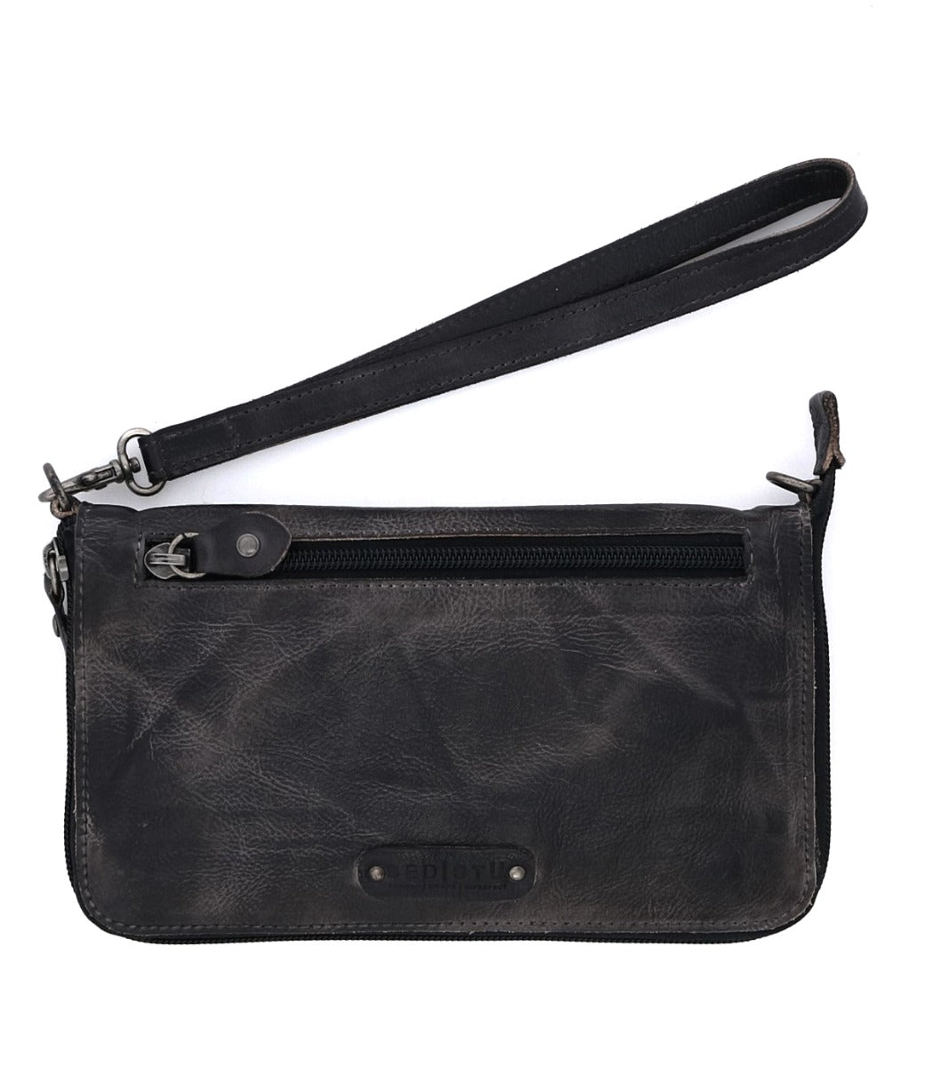 The Templeton II by Bed|Stü is a black leather wristlet featuring a front zipper pocket and a detachable wrist strap, shown against a white background.