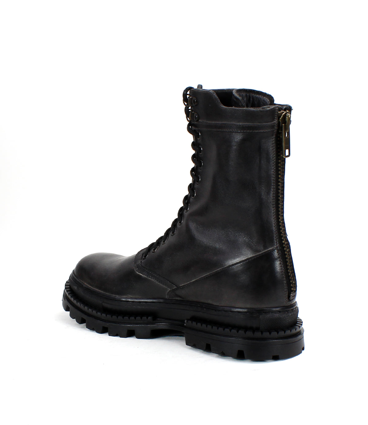 The Bed|Stü Tempt is a black leather lace-up combat boot featuring a side zipper and chunky treaded sole, blending classic combat style with rugged hiking boot elements; it’s displayed at a slight angle against a plain white background.