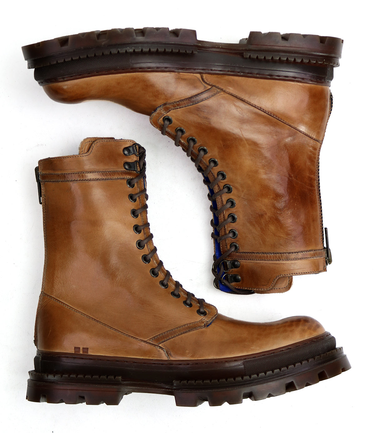 A pair of Bed|Stü Tempt boots in brown leather, featuring lace-up fronts and thick rubber soles, stylishly combining elements of hiking boots and Chelsea boots, are displayed side by side on a white background.