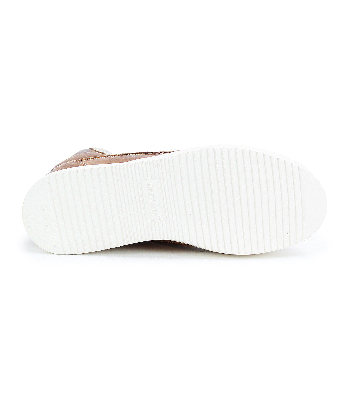 The image displays the bottom view of the Bed|Stü Twist high top sneaker, featuring a white, ribbed rubber sole and a light brown upper visible along the side. Subtle leather panels enhance the texture and style of this unique design.