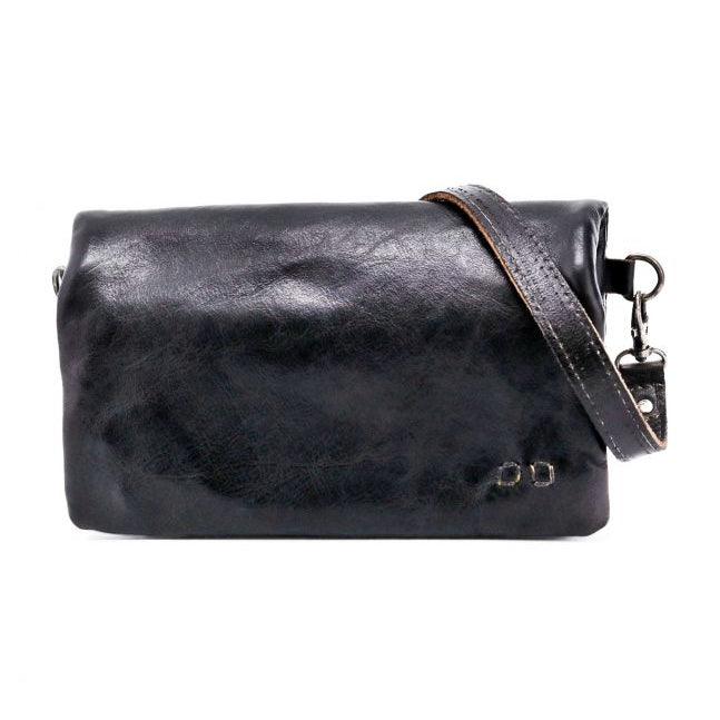 The Cadence by Bed|Stü is a black vegetable-tanned leather crossbody bag featuring a detachable strap and subtle metal detail in the bottom right corner, crafted from luxurious materials and shown against a white background.
