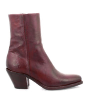 Introducing the Vendue by Bed|Stü—a single maroon Italian leather ankle boot, showcased in profile against a white background. Featuring a mid-high angled heel and a subtly squared toe, this statement piece embodies an avant-garde design sensibility.