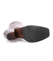 The Bed|Stü Vendue is pictured with its sole facing up, revealing a smooth black sole, stacked heel, and light-colored Italian leather upper finished in a subtle square toe—an understated nod to avant-garde design.