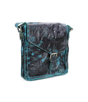 The Bed|Stü Venice Beach is a black and teal full-grain leather crossbody bag featuring a front flap, buckle closure, adjustable strap, and visible stitching, displayed against a plain white background.