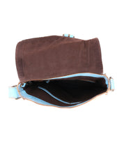 The Bed|Stü Venice Beach open brown suede crossbody bag with a flap, shown from above on a white background, features an adjustable strap and reveals light blue lining with interior compartments.