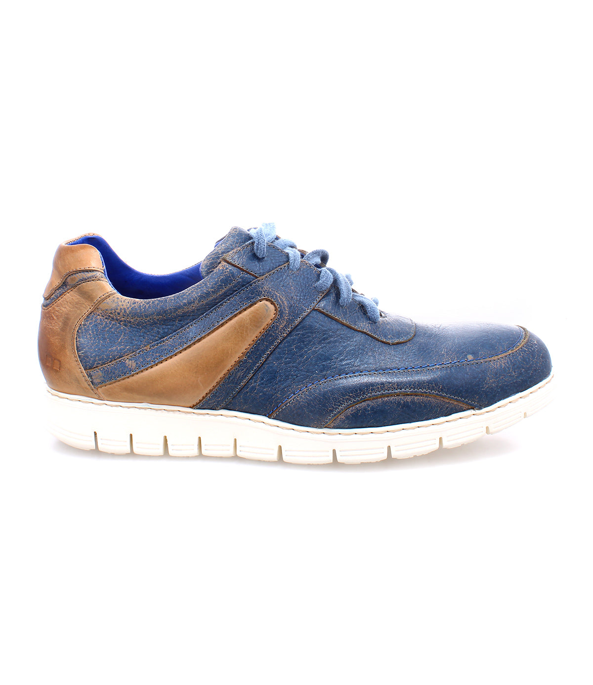 The Bed|Stü Wardell is a blue and brown layered leather sneaker with a modern edge, showcasing blue laces, contrasting stitching, and a white rubber sole—all shown from the side against a white background.