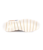 The image shows the white rubber outsole of the Bed|Stü Wardell sneaker, crafted with layered leather and featuring deep horizontal grooves for added traction, as seen from the bottom. This design not only provides secure grip but also suggests a cushioned sole, giving modern flair to classic comfort.