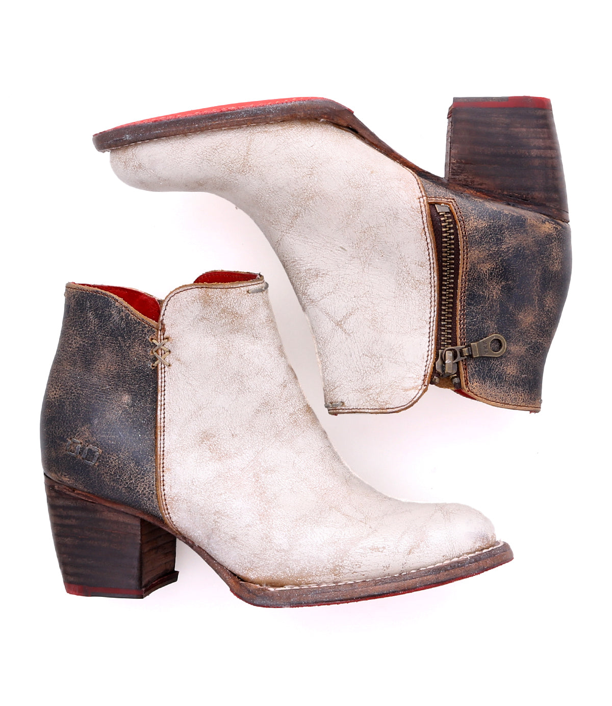 A pair of worn Yell handmade leather ankle boots by Bed|Stü, featuring side zippers, brown heels, a white distressed finish, and a durable Vibram outsole, displayed against a white background.