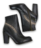 A pair of Bed|Stü Yuno black elevated heel boots with side zippers and decorative stitching detail, featuring contrast leather accents, displayed from the side and bottom views.