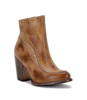 The Yuno ankle boot by Bed|Stü features rich brown leather with contrast leather accents, a stacked chunky heel, decorative stitching, and a slightly pointed toe, displayed against a white background. Designed for comfort with breathable cushioning, these elevated heel boots seamlessly blend style and support.