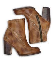 Showcased from both the outer and inner sides against a white background, the Bed|Stü Yuno boots are a pair of brown leather elevated heel boots with side zippers, decorative stitching, and contrasting leather accents.