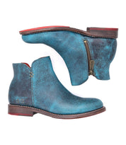 A pair of Yurisa blue leather ankle boots by Bed|Stü, featuring brown leather outsoles, a side zipper, and red interior accents, displayed side by side on a white background—an elegant example of handcrafted footwear.