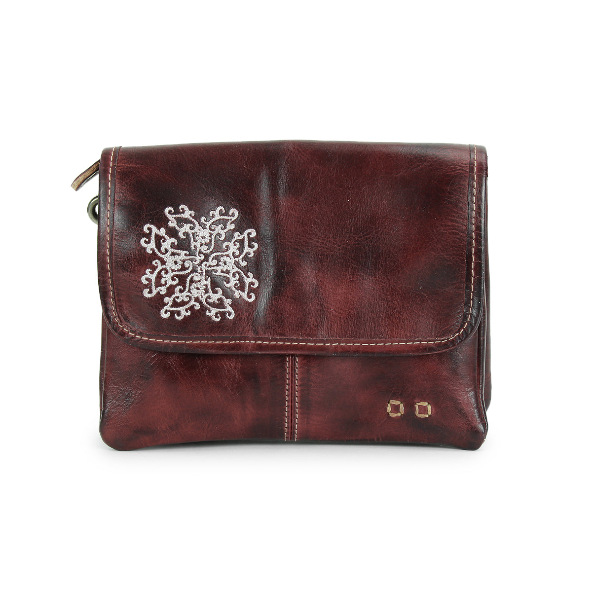 Introducing the Ziggy JB by Bed|Stü—a small brown leather crossbody bag featuring a flap closure, accented with a silver snowflake design and two metal studs on the bottom right corner. This stylish accessory is perfect for carrying your essentials while adding an elegant touch to any outfit.