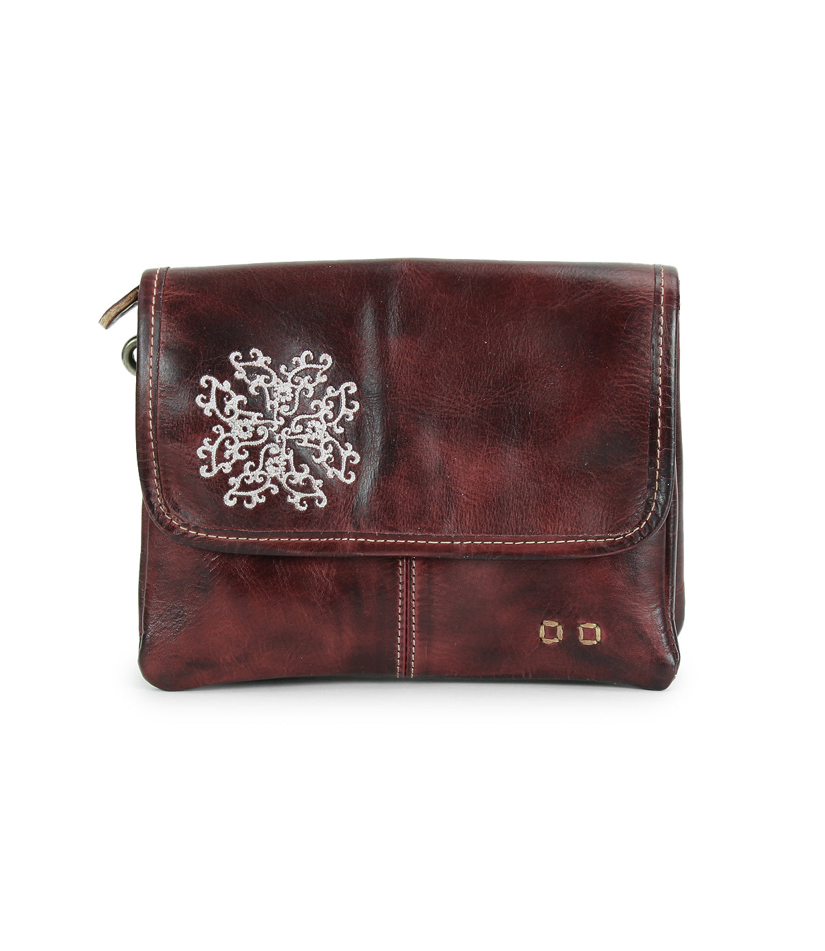 Introducing the Ziggy JB by Bed|Stü—a small brown leather crossbody bag featuring a flap closure, accented with a silver snowflake design and two metal studs on the bottom right corner. This stylish accessory is perfect for carrying your essentials while adding an elegant touch to any outfit.